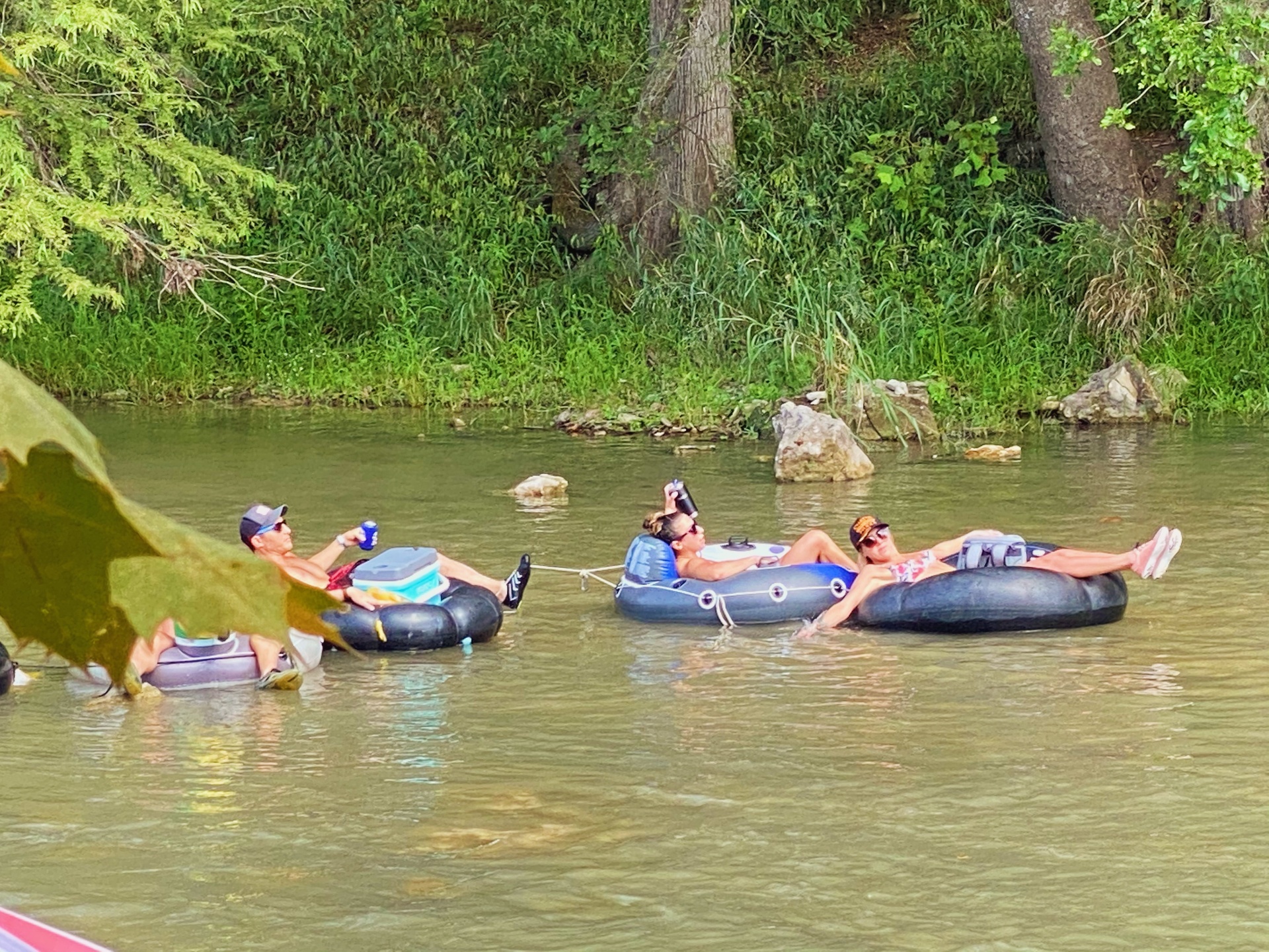 Friends floating with cooler on the river