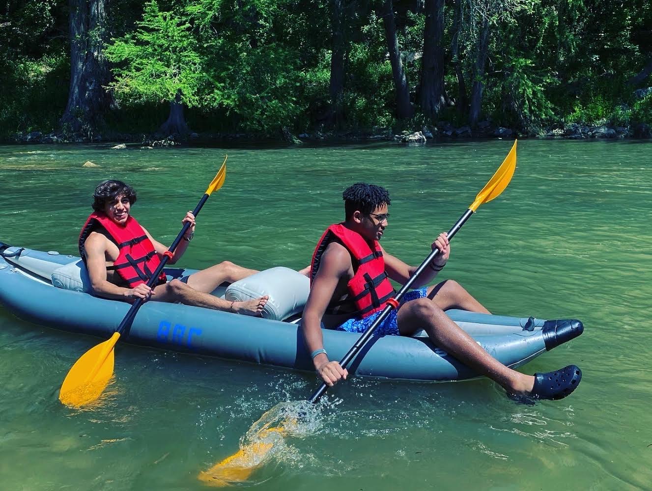 Friends kayaking down the river