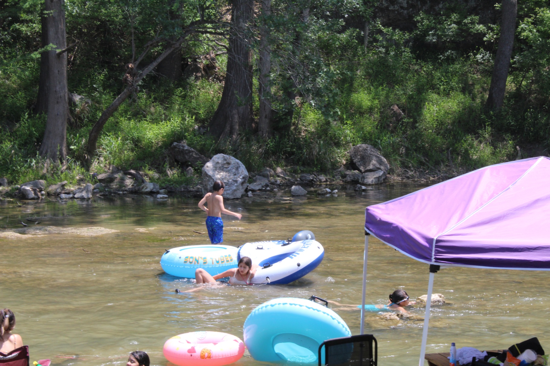 Kids playing with tubes in the river